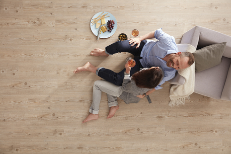 wineo PURLINE Bioboden wineo PURLINE Bioboden Wohnzimmer Mann Frau Sessel Teller Essen Weingläser