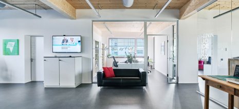 wineo PURLINE Bioboden im Büro dunkle Fliesen Fußboden Bodenbelag Sofa moderne Einrichtung Agentur