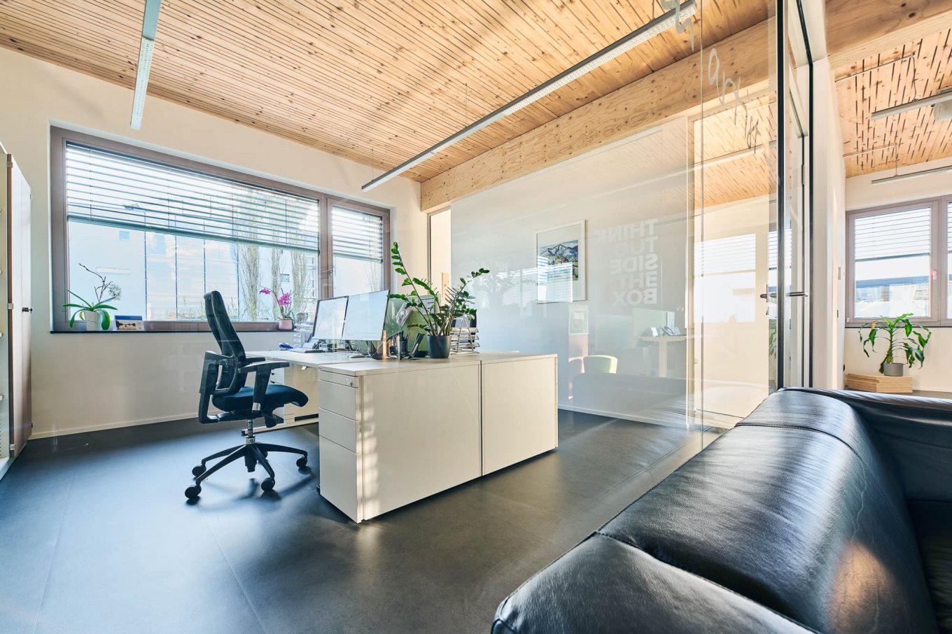 wineo PURLINE Bioboden Referenz Büro Schreibtisch Schreibtischstuhl Sofa mit dunklem Fußboden