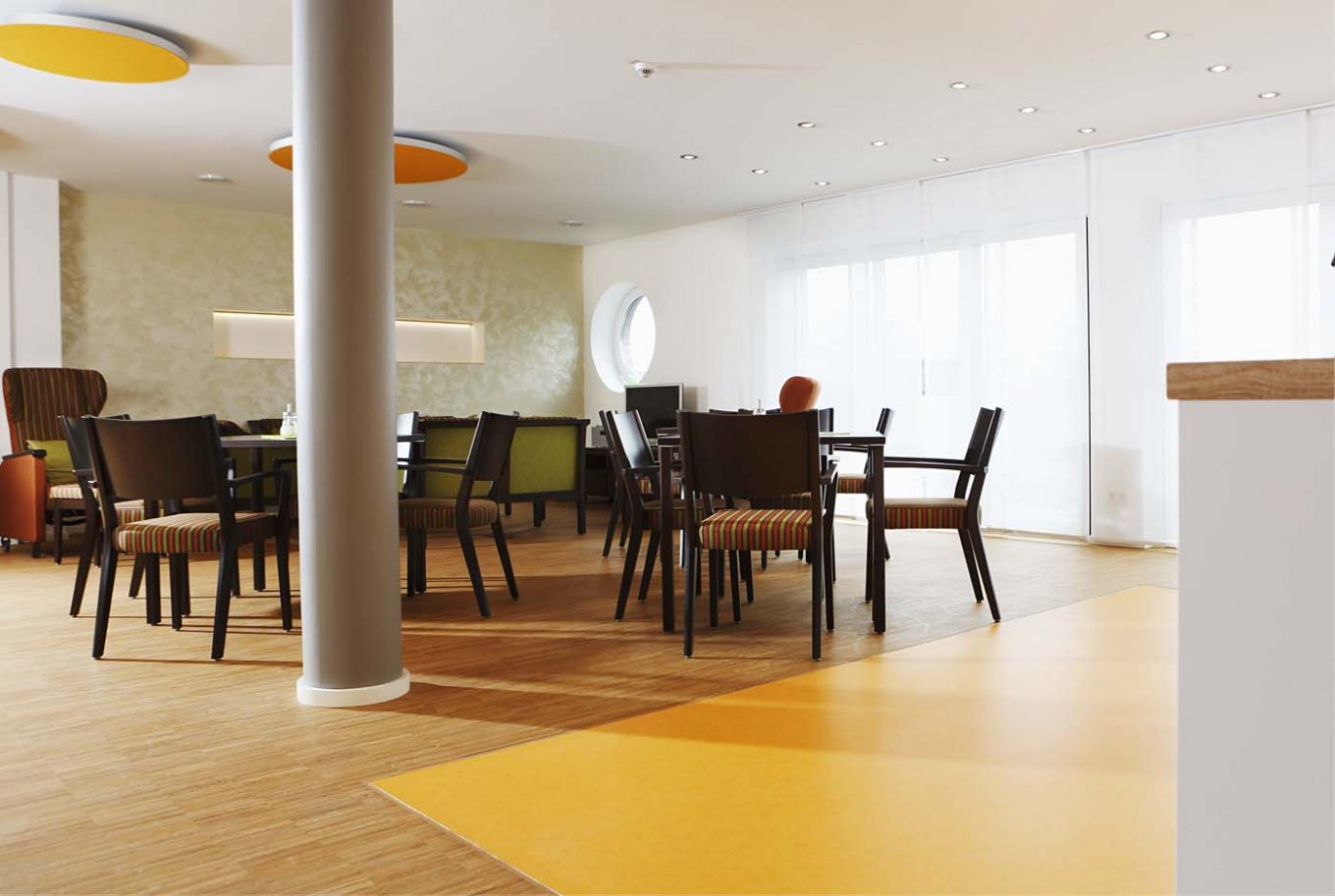 wineo PURLINE Bioboden im Altenpflege Bodeneblag grün Kantine Esszimmer Stühle Tische orange
