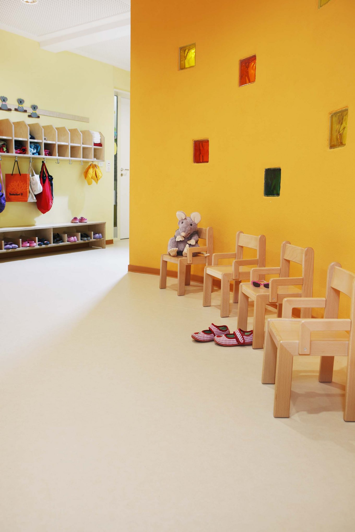 PURLINE Bioboden Sinai Sand in KiTa Kindergarten Eingangsbereich Stühle Rollenware Orange