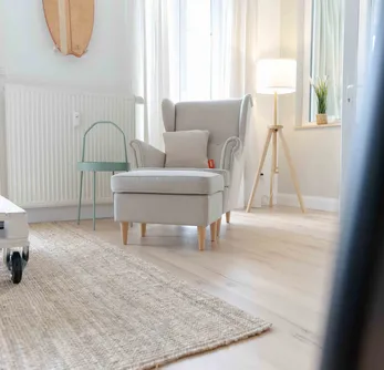 wineo PURLINE Bioboden Sessel mit Palettentisch auf rustikalen Holzfußboden