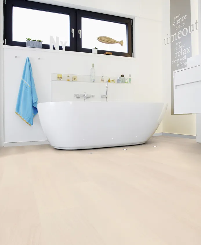 Badezimmer mit freistehender Badewanne und hellem Holzfußboden