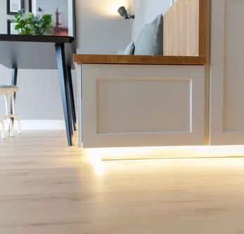 wineo PURLINE Bioboden Esszimmer mit LED's beleuchteter Küche, Hockern und hellem Holzfußboden