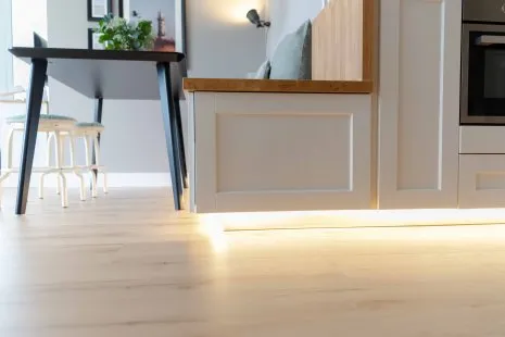 Esszimmer mit LED's beleuchteter Küche, Hockern und hellem Holzfußboden