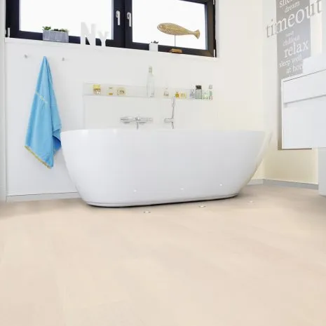 Badezimmer mit freistehender Badewanne und hellem Holzfußboden