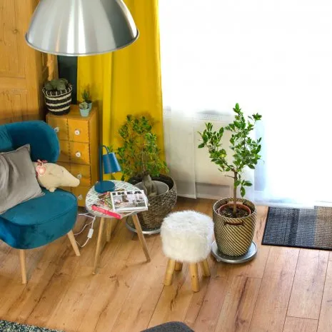wineo Laminatboden Holzoptik Retro Einrichtung Sessel Stuhl Teppich Pflanzen Blumen Wohnzimmer