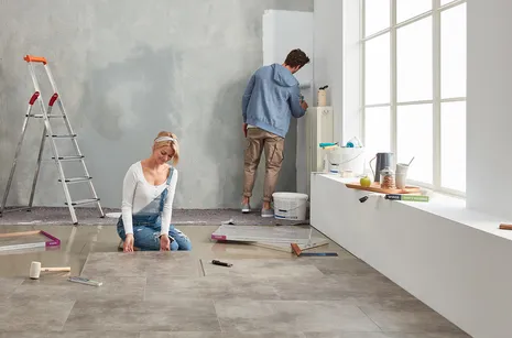 Designboden wineo 600 Frau und Mann renovieren ein Loft mit modernem Vinylboden in heller Betonoptik